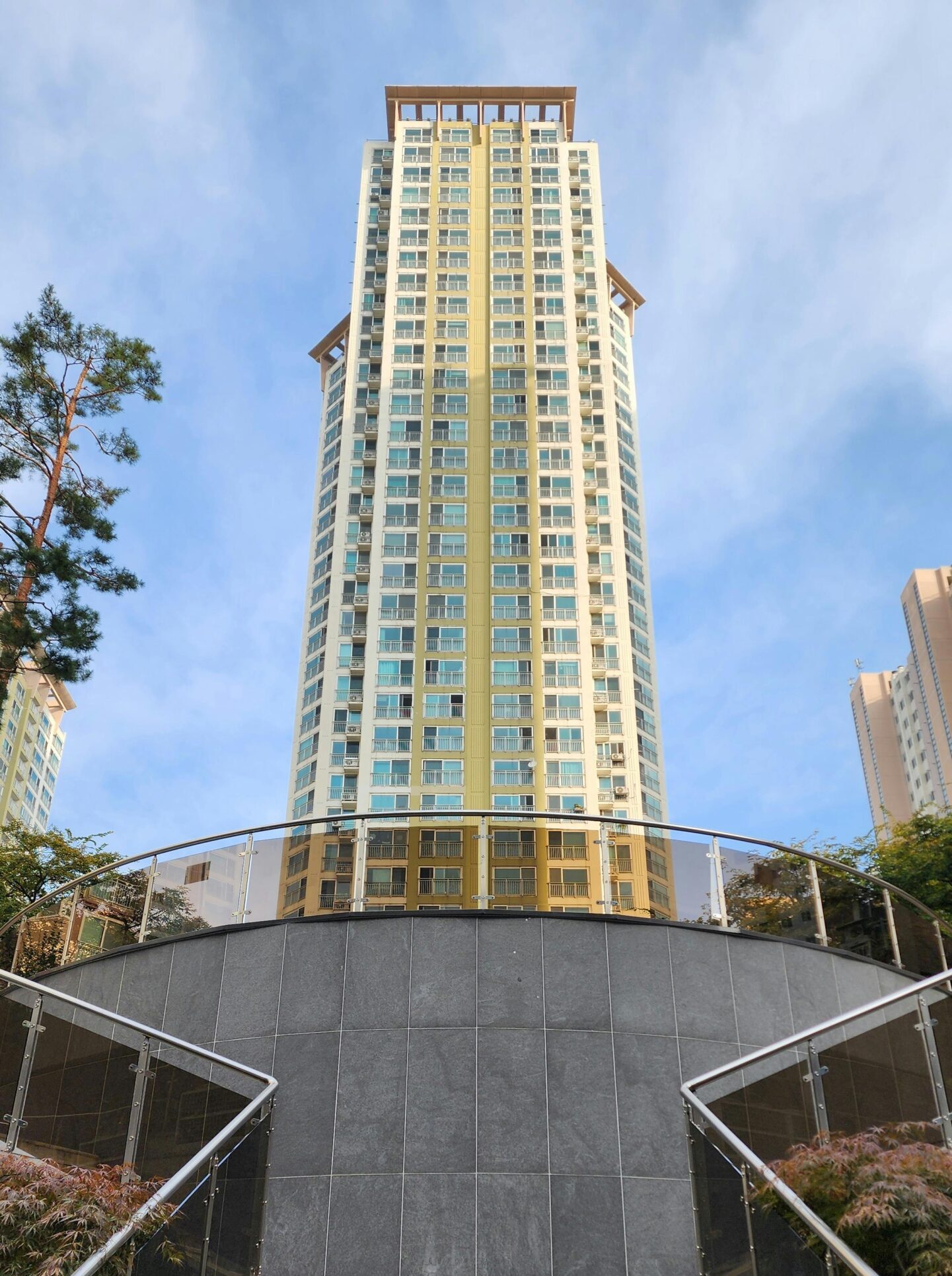 Upward view of a tall modern building with stairs in urban setting.