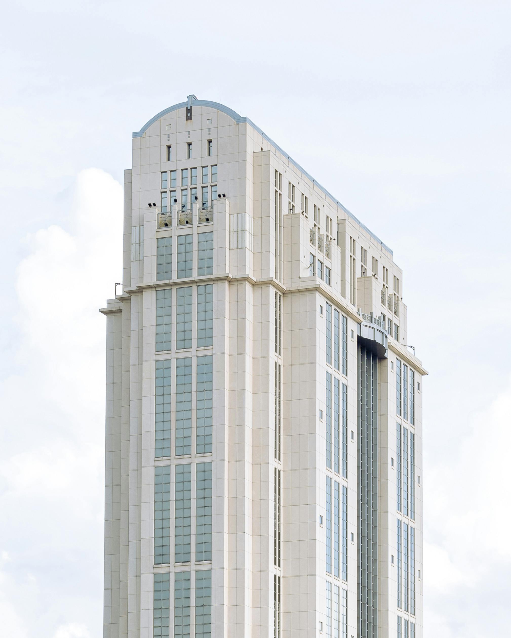 High-rise building with modern architectural design against a cloudy sky.